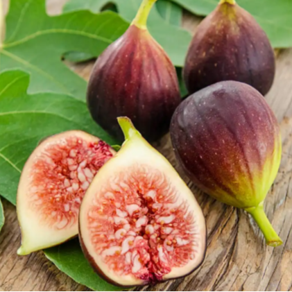 Figs on a wooden surface with green leaves